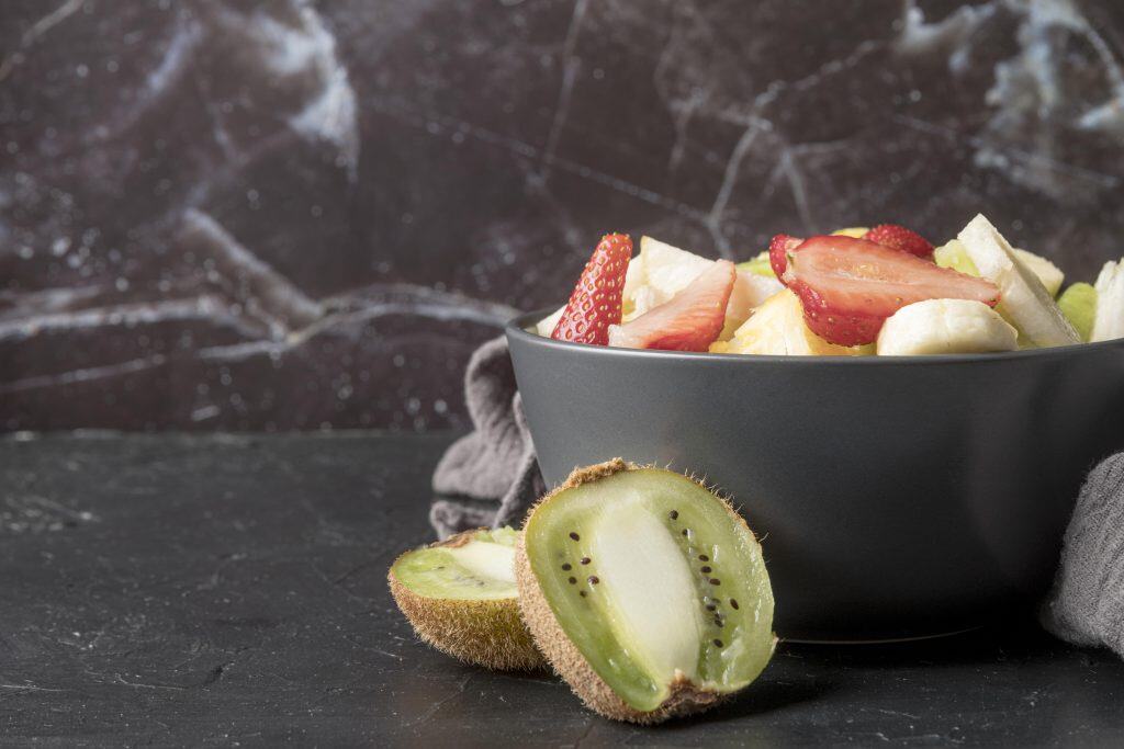 A wooden table filled with fresh ingredients including beans, broccoli, and oats, representing a variety of foods that have high fiber.
