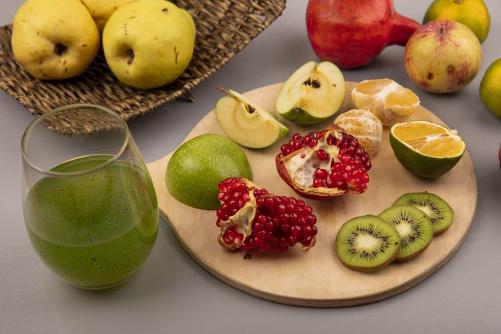 A close up shot of a sliced pear and a bowl of fresh raspberries, highlighting fruit foods that have high fiber